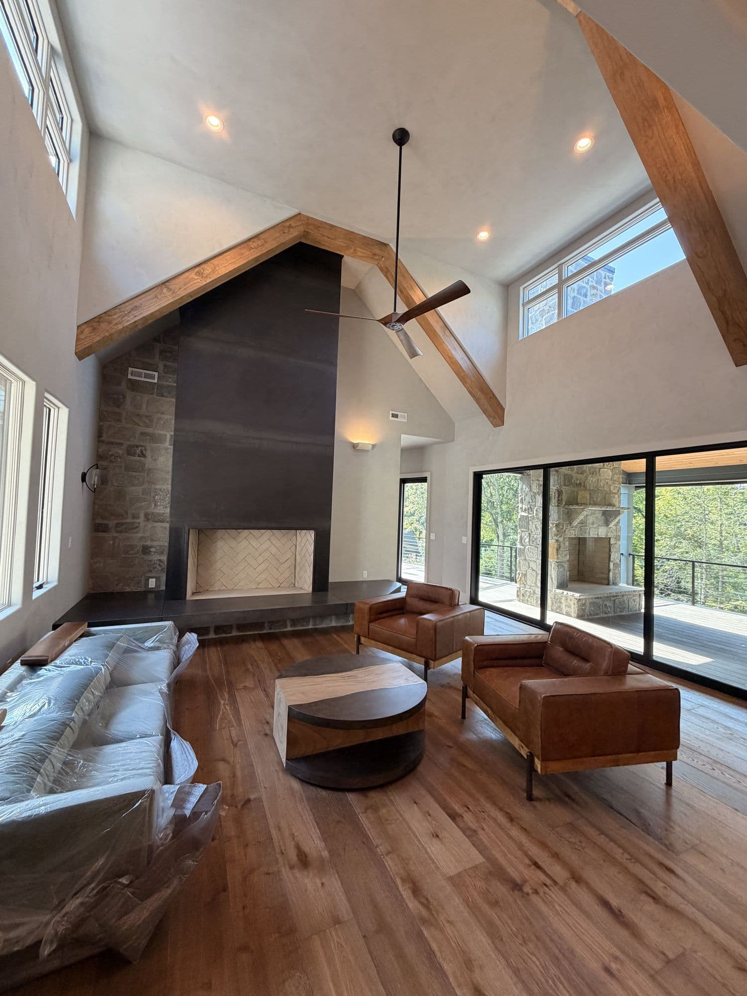 Vaulted great room with exposed timber trusses and a floor-to-ceiling fireplace