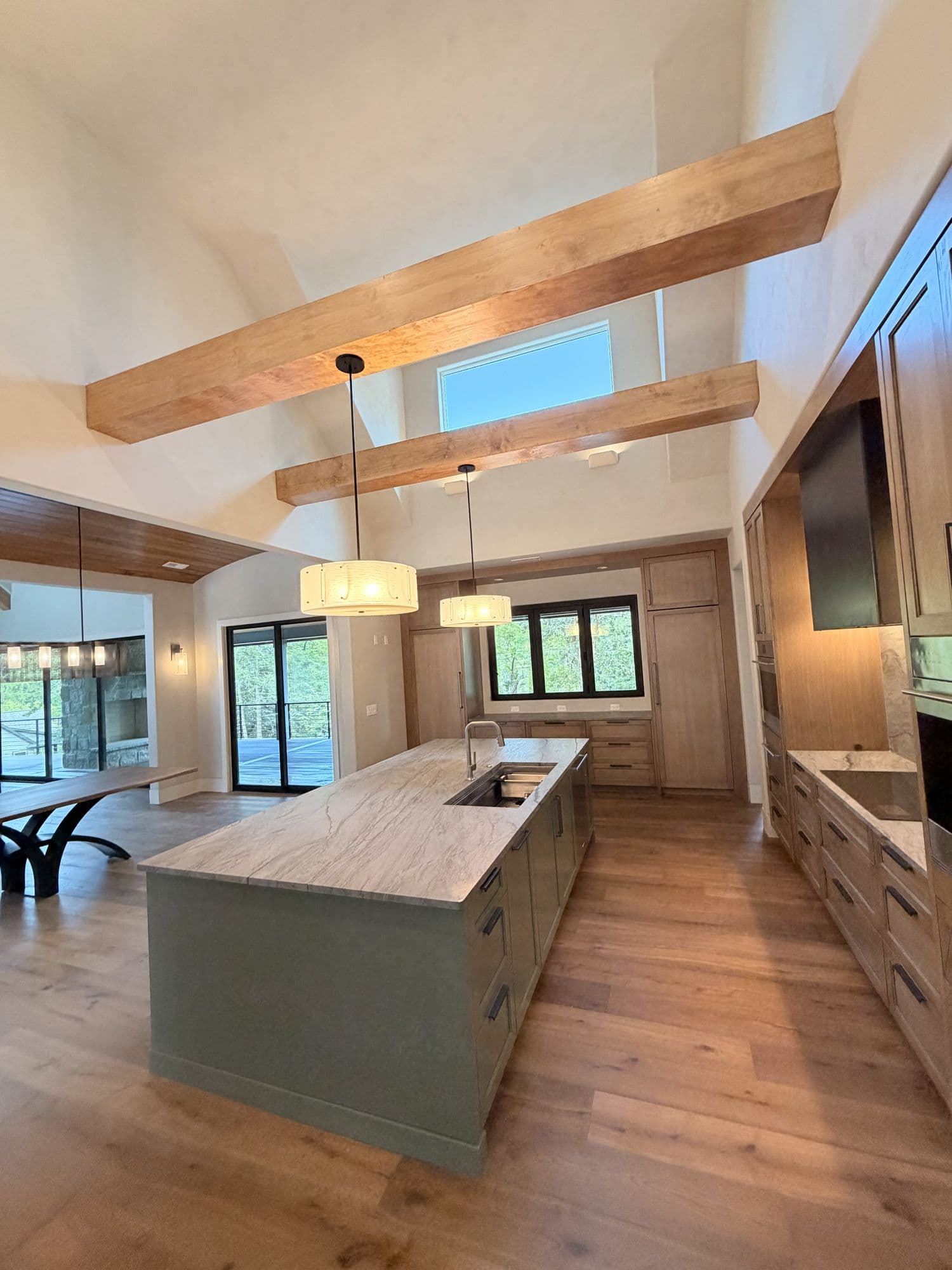 Kitchen and great room with timber beams and an island